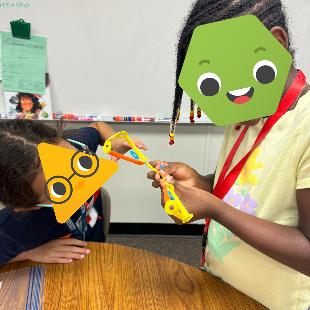 Two students working with Strawbees.