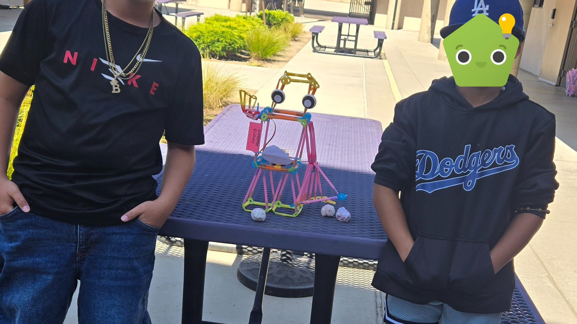 Two students standing next to a Friendbot.