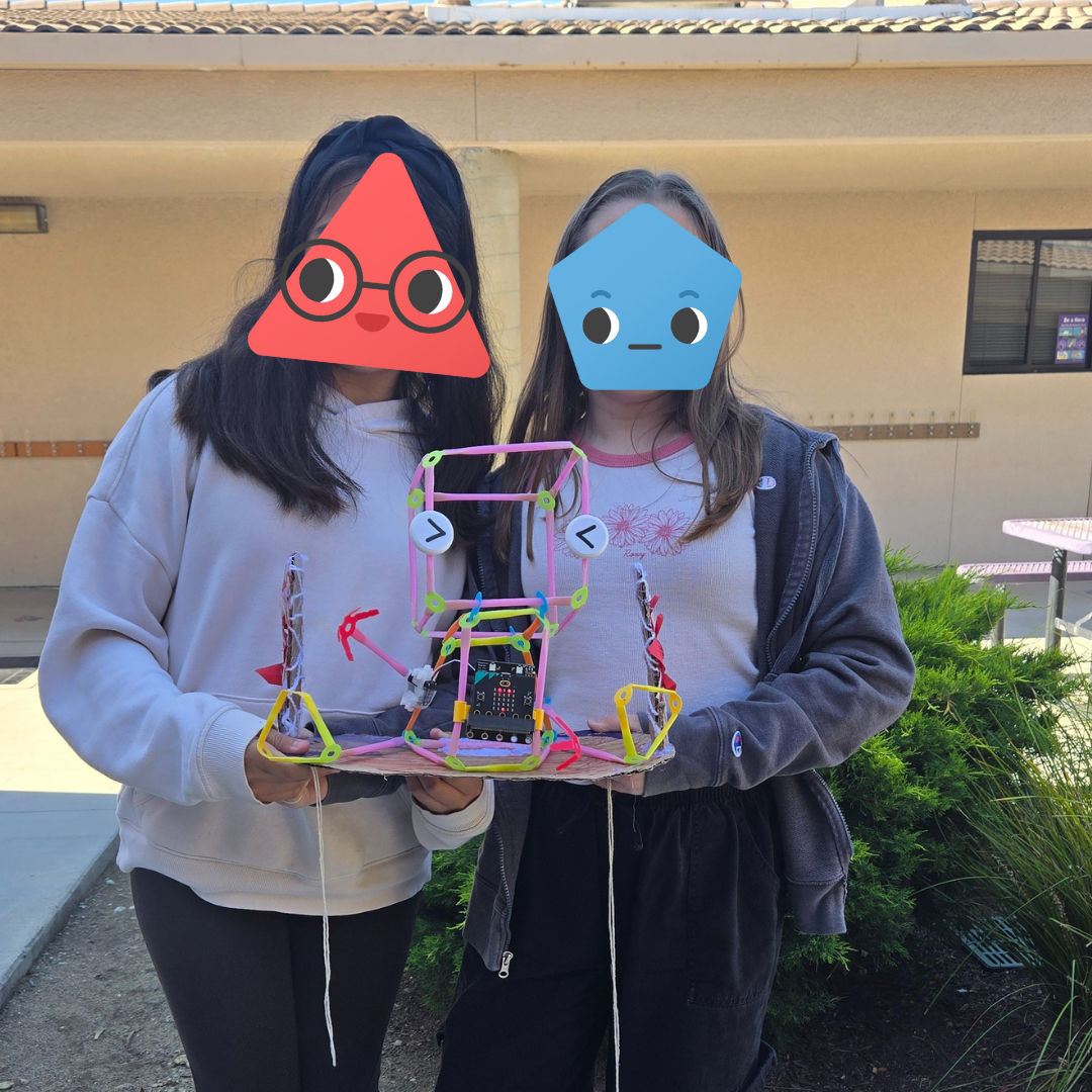 Two students holding a Friendbot.