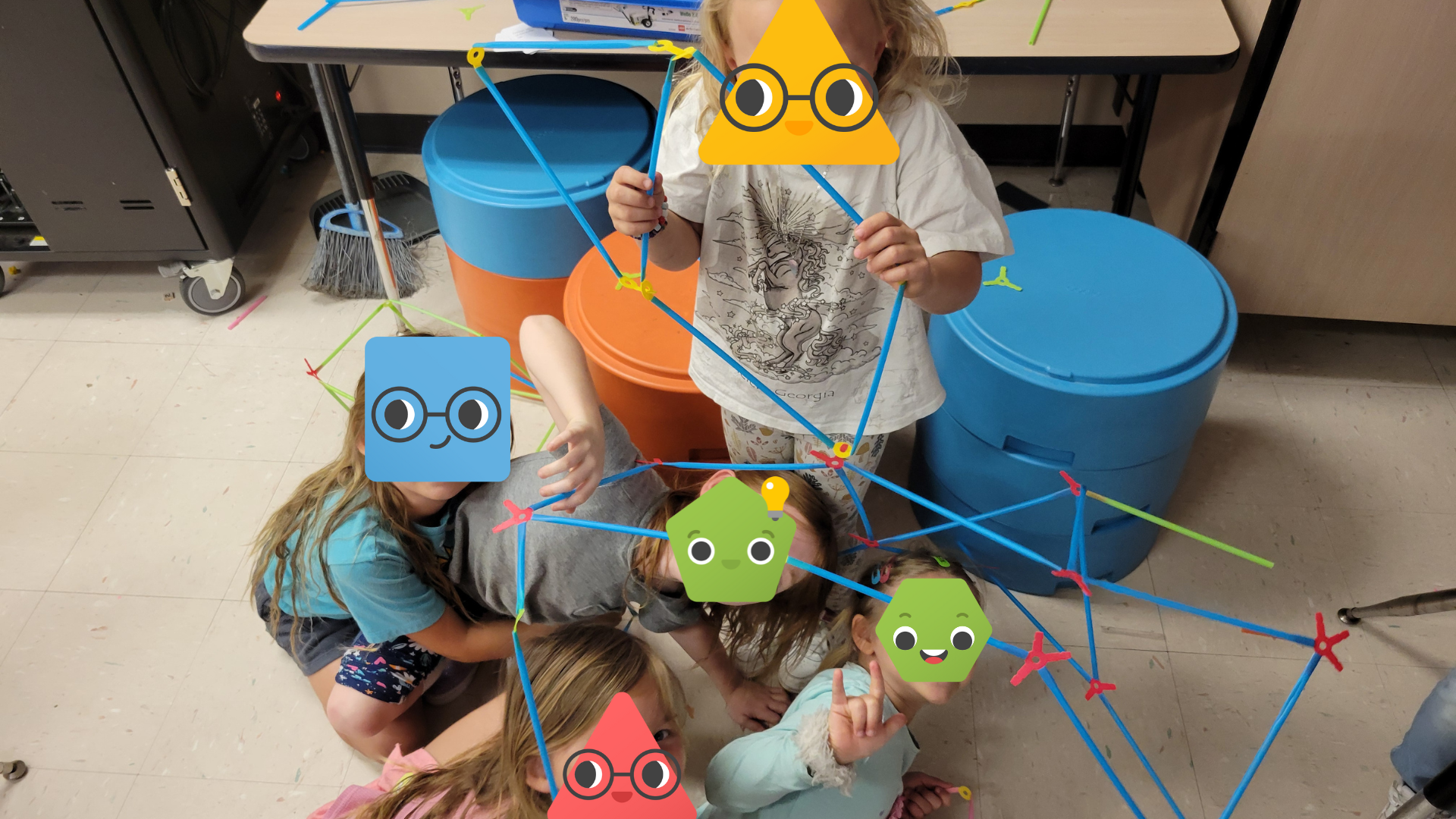 A group of students holding a Strawbees structure.